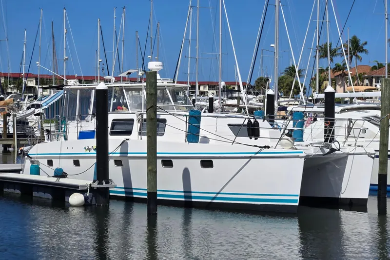Slide: The Image of 2003 Endeavour Trawler Cat 44 docked at a marina with sailboats in the background. - 112