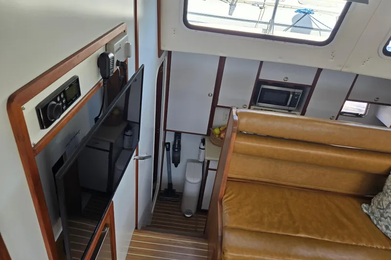 Slide: The Image of Interior of 2003 Endeavour Trawler Cat 44 with seating, TV, and kitchen area. - 17