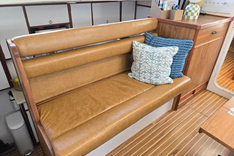 Slide: The Image of Cozy seating area on 2003 Endeavour Trawler Cat 44 with cushions and wooden cabinetry. - 24