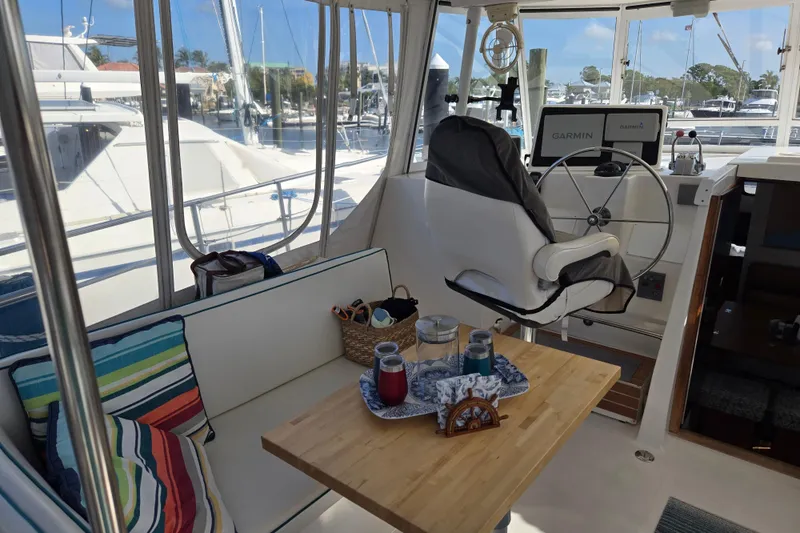 Slide: The Image of Interior of 2003 Endeavour Trawler Cat 44 with helm, seating, and table setup. - 27