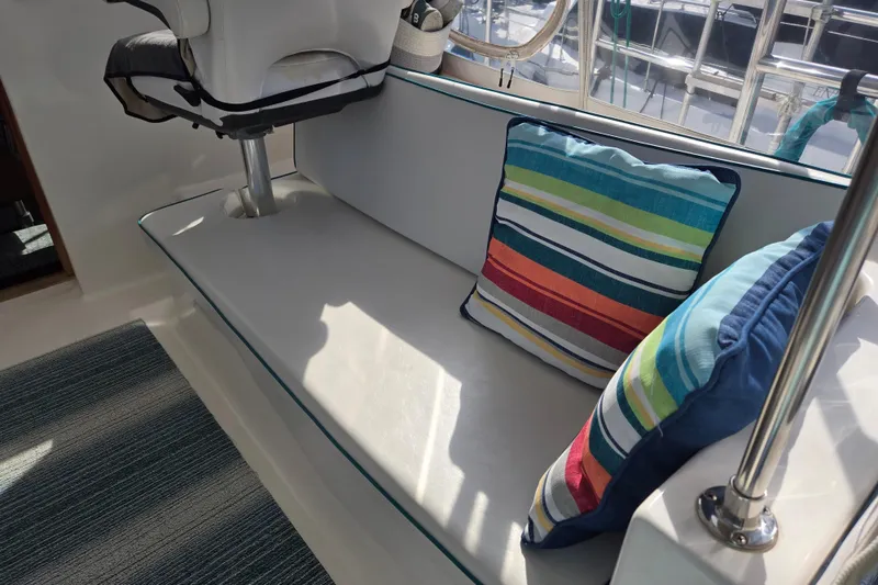 Slide: The Image of Interior seating of 2003 Endeavour Trawler Cat 44 with colorful striped cushions. - 29