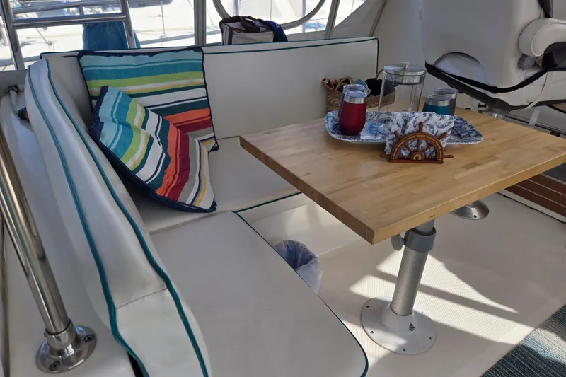 Slide: The Image of Cozy seating area on 2003 Endeavour Trawler Cat 44 with colorful cushions and wooden table. - 30