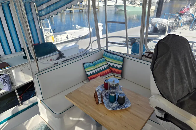 Slide: The Image of Cozy seating area on 2003 Endeavour Trawler Cat 44 with striped cushions and tableware. - 31