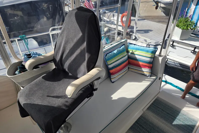 Slide: The Image of Cozy seating area on 2003 Endeavour Trawler Cat 44 with striped cushions and covered chair. - 32
