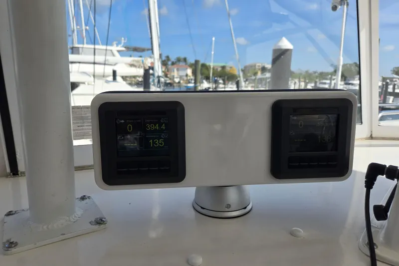 Slide: The Image of Control panel on 2003 Endeavour Trawler Cat 44, displaying engine metrics in a marina setting. - 39