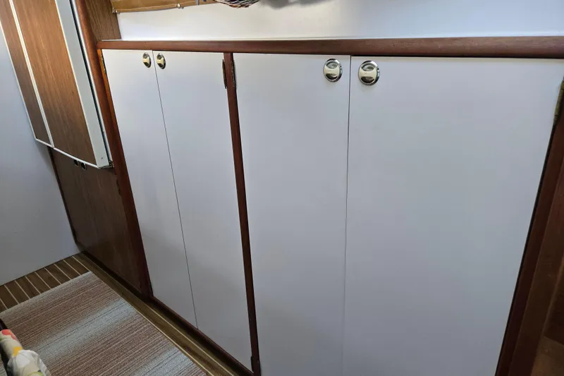 Slide: The Image of Wooden cabinetry inside 2003 Endeavour Trawler Cat 44, featuring sleek white doors and chrome handles. - 50