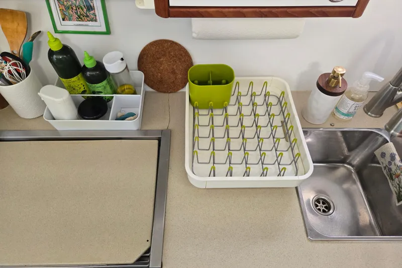 Slide: The Image of Kitchen counter with dish rack, sink, and utensils on Endeavour Trawler Cat 44, 2003. - 54