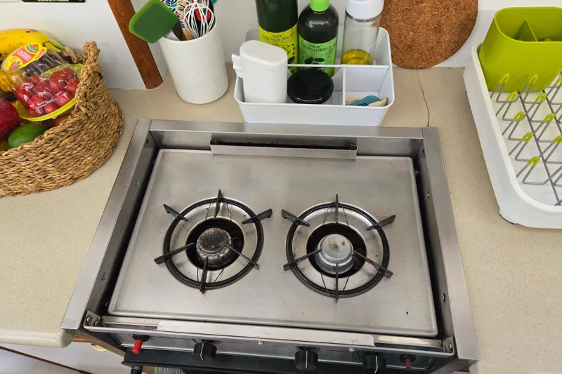 Slide: The Image of Compact kitchen stove on Endeavour Trawler Cat 44, surrounded by cooking essentials and fruit basket. - 57