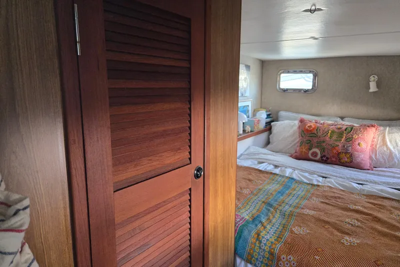 Slide: The Image of Cozy bedroom interior of 2003 Endeavour Trawler Cat 44 with colorful bedding and wooden door. - 59
