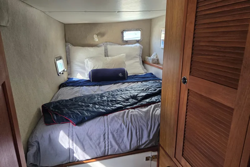 Slide: The Image of Cozy bedroom interior of 2003 Endeavour Trawler Cat 44 with bed and wooden cabinetry. - 62