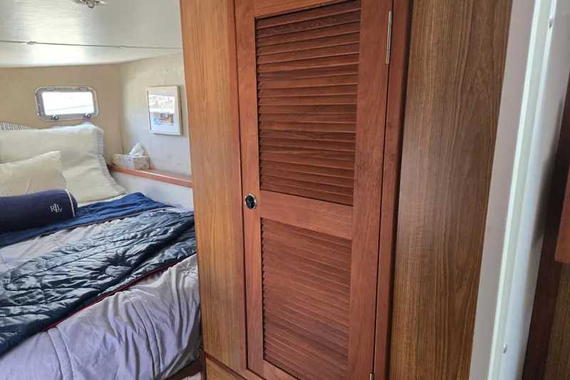 Slide: The Image of Cozy bedroom interior of 2003 Endeavour Trawler Cat 44 with wooden closet and bed. - 64
