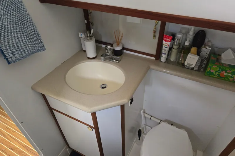 Slide: The Image of Bathroom interior of 2003 Endeavour Trawler Cat 44 with sink, toiletries, and towel. - 71