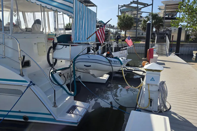 Slide: The Image of 2003 Endeavour Trawler Cat 44 docked with American flags and striped canopy. - 76