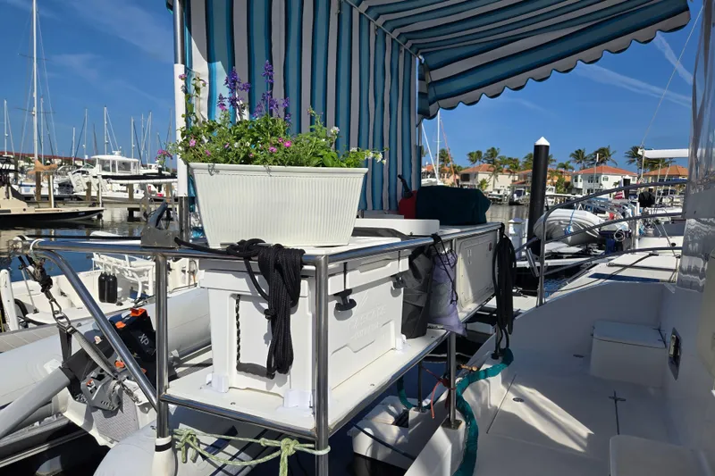 Slide: The Image of 2003 Endeavour Trawler Cat 44 with striped awning and potted flowers at marina. - 79
