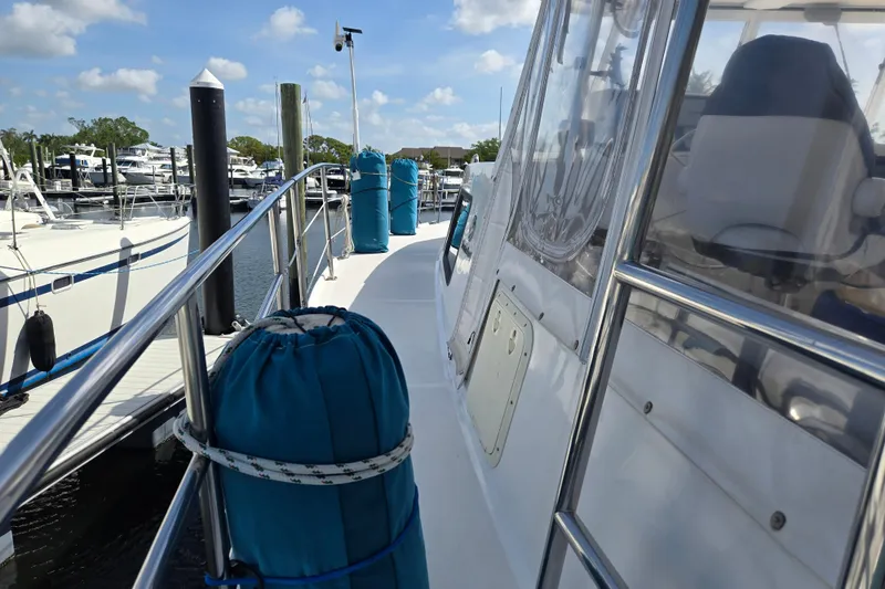 Slide: The Image of 2003 Endeavour Trawler Cat 44 docked at marina, featuring deck and railing view. - 81
