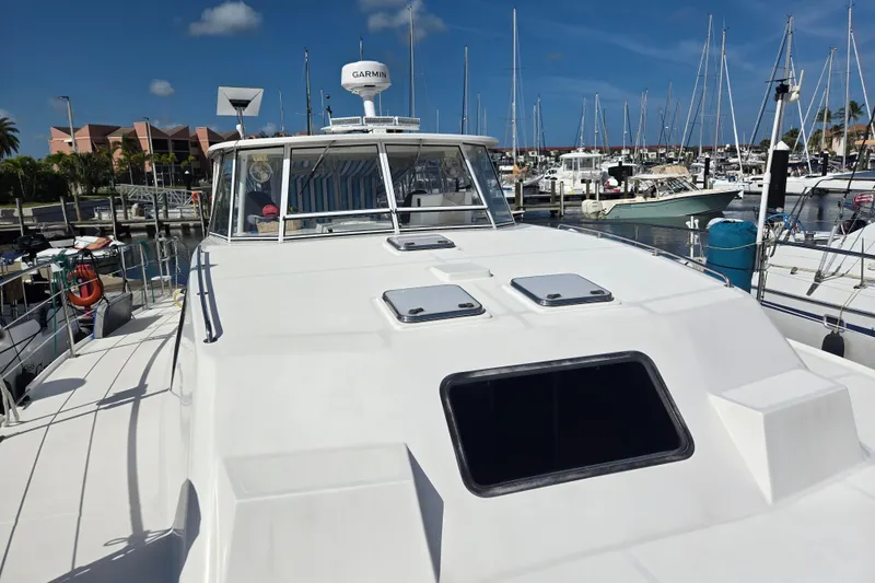 Slide: The Image of 2003 Endeavour Trawler Cat 44 docked at a marina under clear blue skies. - 89