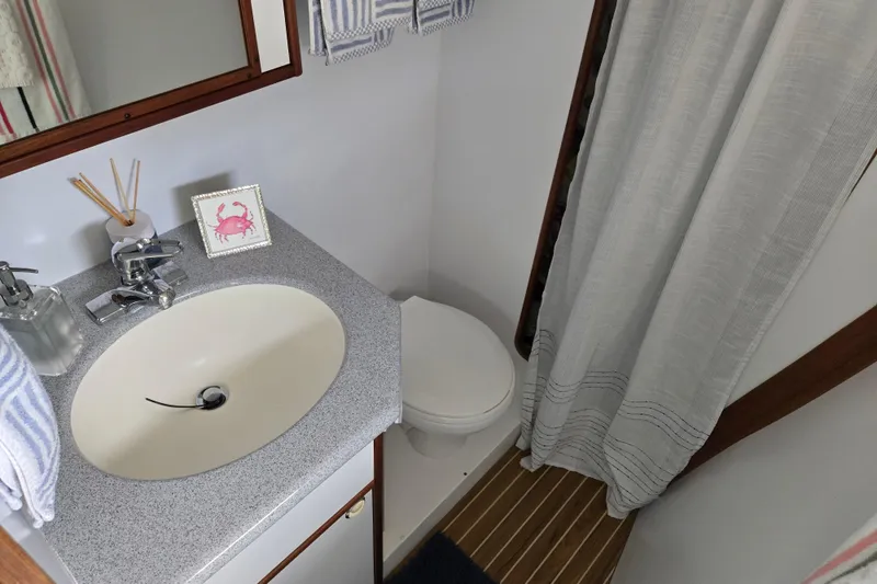Slide: The Image of Bathroom interior of 2003 Endeavour Trawler Cat 44 with sink, toilet, and shower curtain. - 9