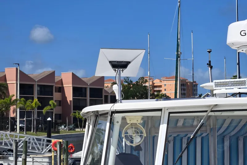 Slide: The Image of 2003 Endeavour Trawler Cat 44 docked, featuring a satellite dish, with buildings in the background. - 90
