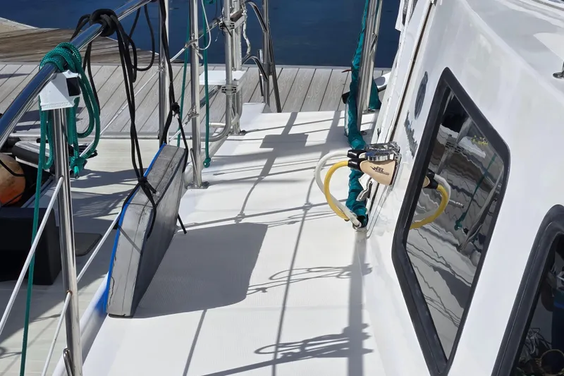 Slide: The Image of 2003 Endeavour Trawler Cat 44 deck with railing, ropes, and dockside view. - 92