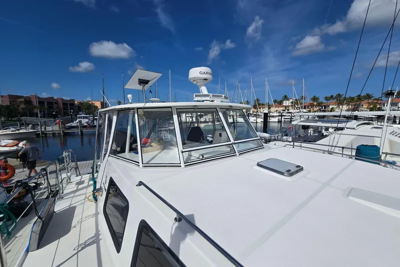 Slide: The Image of 2003 Endeavour Trawler Cat 44 docked at a marina under a clear blue sky. - 93