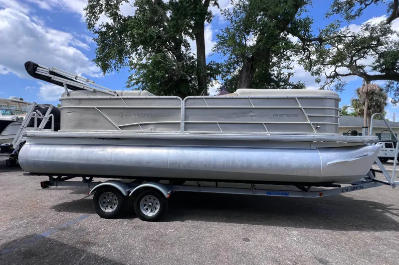 The Image of 2020 Godfrey Sweetwater 2286 Tritoon on trailer, parked outdoors under trees. - 0