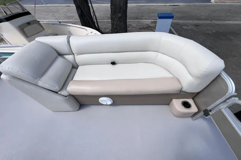 Slide: The Image of Luxurious seating on 2020 Godfrey Sweetwater 2286 Tritoon boat, featuring plush cushions and cup holder. - 12