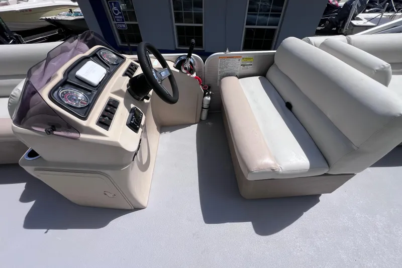 Slide: The Image of 2020 Godfrey Sweetwater 2286 Tritoon helm with beige seating and steering console. - 18