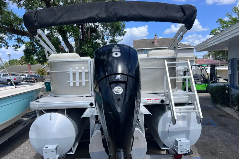 Slide: The Image of 2020 Godfrey Sweetwater 2286 Tritoon with outboard motor, parked outdoors. - 3