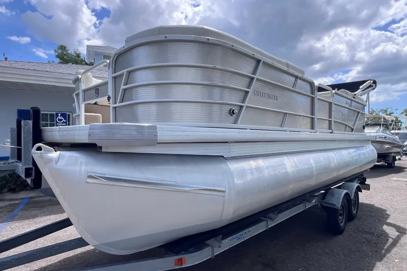 Slide: The Image of 2020 Godfrey Sweetwater 2286 Tritoon boat on trailer under cloudy sky. - 6