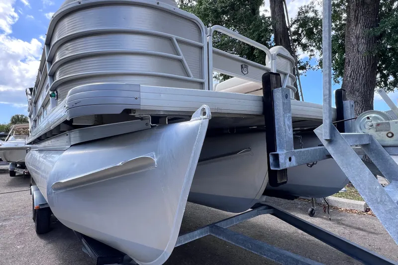 Slide: The Image of 2020 Godfrey Sweetwater 2286 Tritoon on trailer, showcasing sleek aluminum pontoons. - 9