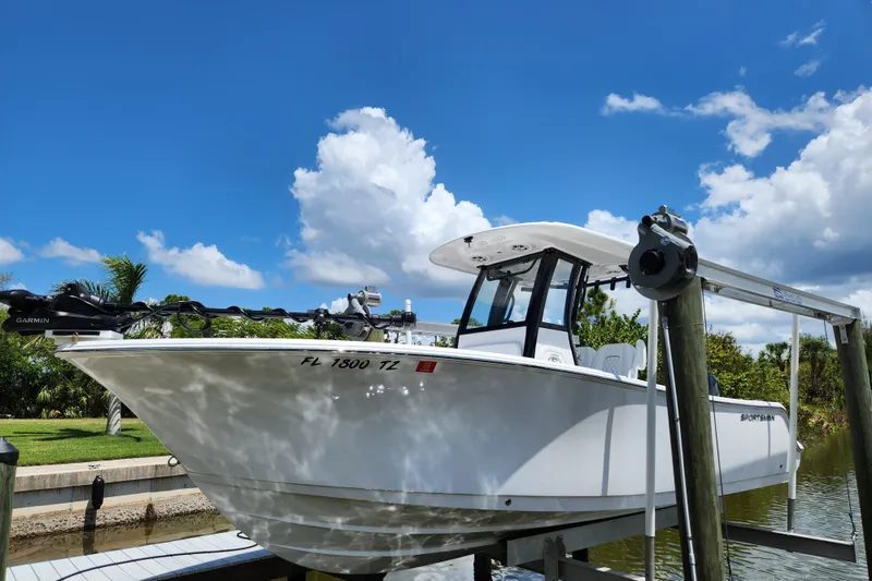 The Image of 2024 Sportsman Open 232 Center Console boat on lift under clear blue sky. - 0
