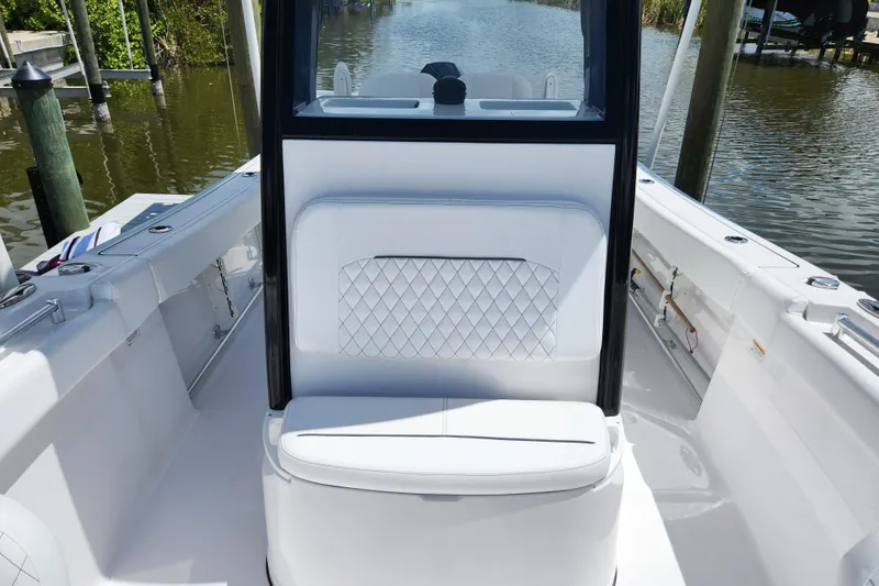 Slide: The Image of 2024 Sportsman Open 232 Center Console boat interior with cushioned seating and water view. - 11