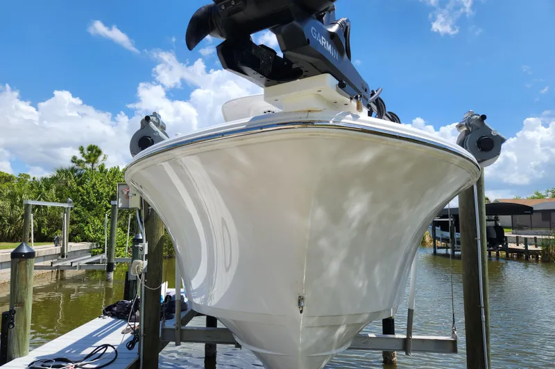 Slide: The Image of 2024 Sportsman Open 232 Center Console boat docked on a sunny day. - 2
