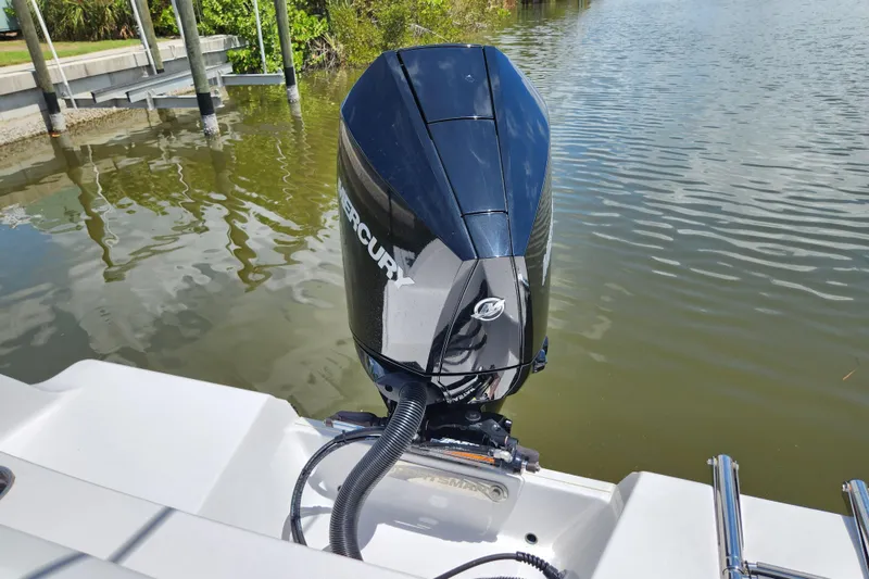 Slide: The Image of 2024 Sportsman Open 232 Center Console with Mercury outboard motor on calm water. - 20