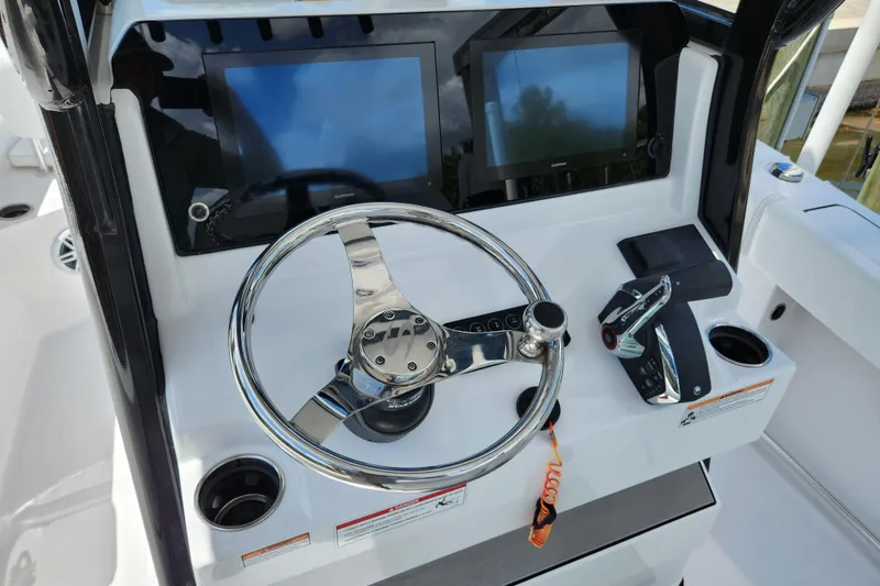 Slide: The Image of 2024 Sportsman Open 232 Center Console dashboard with dual screens and steering wheel. - 27