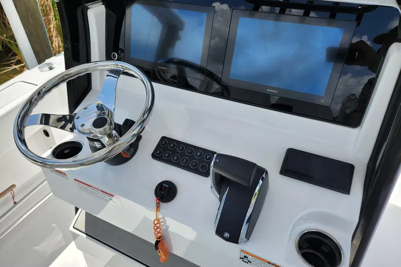 Slide: The Image of 2024 Sportsman Open 232 Center Console dashboard with steering wheel and dual Garmin displays. - 28