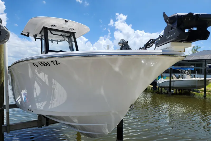 Slide: The Image of 2024 Sportsman Open 232 Center Console boat docked, featuring Garmin equipment under a clear sky. - 3
