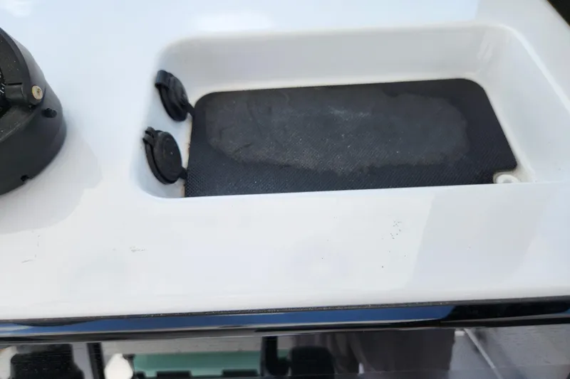Slide: The Image of 2024 Sportsman Open 232 Center Console boat detail with storage compartment and plug sockets. - 30