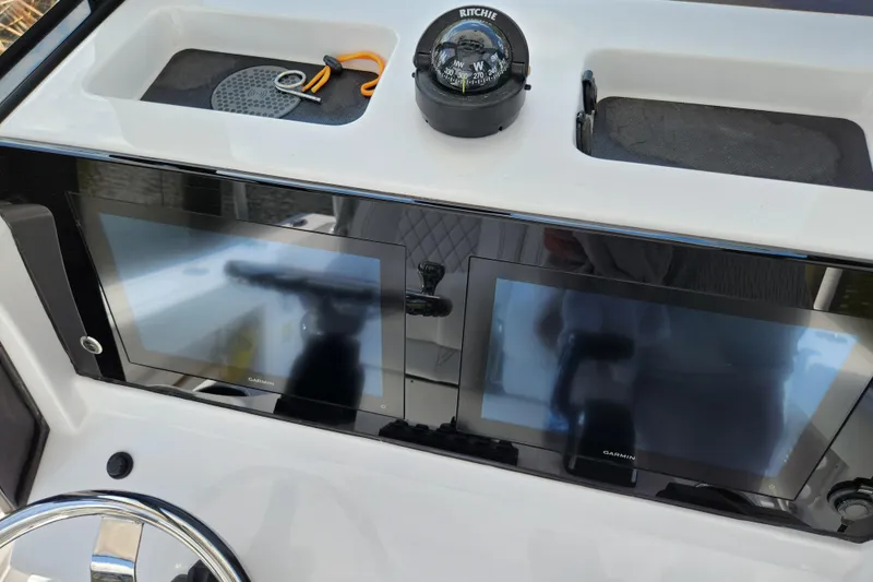 Slide: The Image of 2024 Sportsman Open 232 Center Console dashboard with dual Garmin displays and compass. - 31