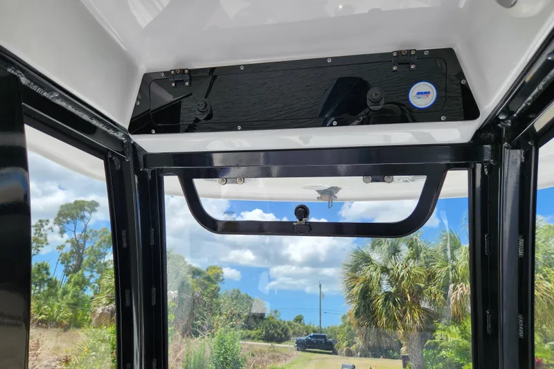 Slide: The Image of 2024 Sportsman Open 232 Center Console interior view with clear sky and palm trees. - 32