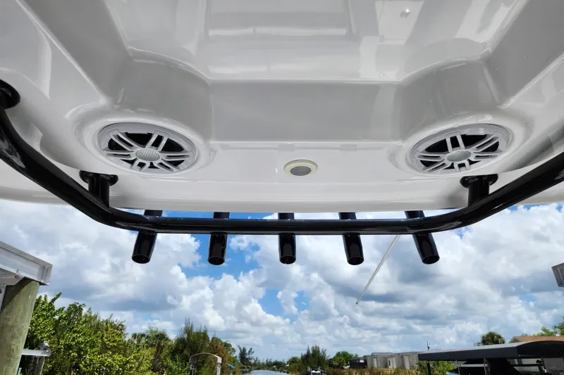 Slide: The Image of 2024 Sportsman Open 232 Center Console boat speakers and rod holders under blue sky. - 35