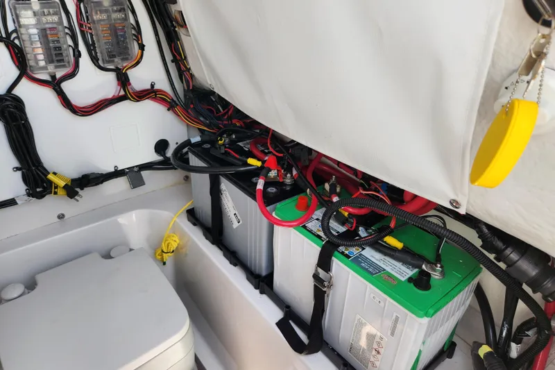 Slide: The Image of 2024 Sportsman Open 232 Center Console boat battery compartment with wiring and components. - 40