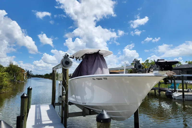 Slide: The Image of 2024 Sportsman Open 232 Center Console boat docked by a scenic waterway. - 47