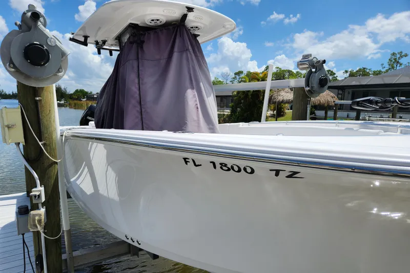 Slide: The Image of 2024 Sportsman Open 232 Center Console boat docked, featuring sleek white hull and registration number. - 48