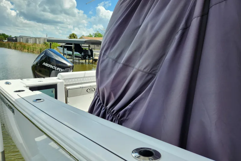 Slide: The Image of 2024 Sportsman Open 232 Center Console boat with Mercury engine on a calm waterway. - 49