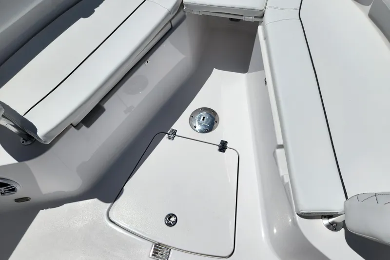 Slide: The Image of 2024 Sportsman Open 232 Center Console boat interior with cushioned seating and storage hatch. - 5