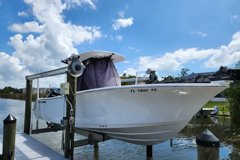 Slide: The Image of 2024 Sportsman Open 232 Center Console boat docked under a clear blue sky. - 51