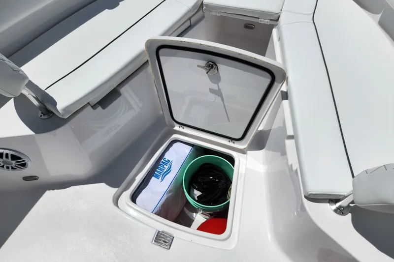 Slide: The Image of 2024 Sportsman Open 232 Center Console storage compartment with seating and marine accessories. - 6