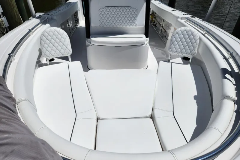 Slide: The Image of 2024 Sportsman Open 232 Center Console boat with white cushioned seating and diamond-patterned backrests. - 8