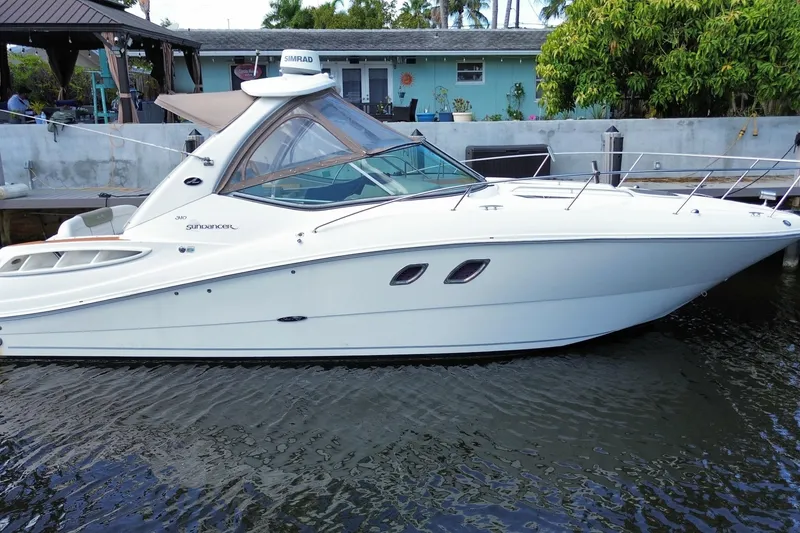 Slide: The Image of 2007 Sea Ray Sundancer 310 boat docked by a waterfront home. - 13
